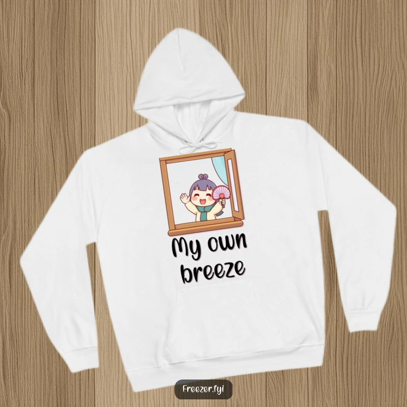 Funny hoodie showing a character enthusiastically fanning a small fan at a frost-covered window. Cozy and humorous winter wear.